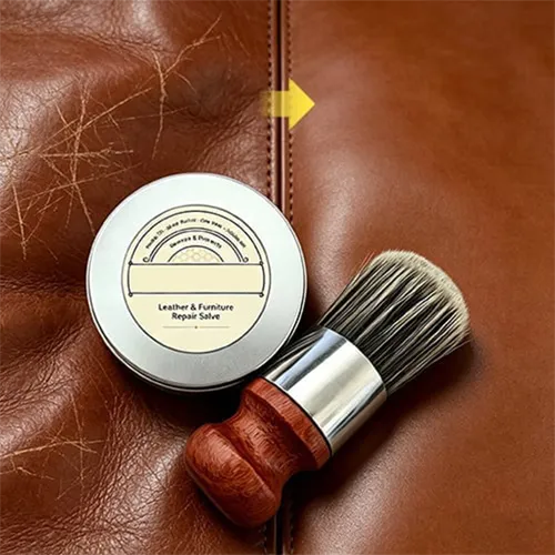 Leather care cream and applicator brush beside a leather surface